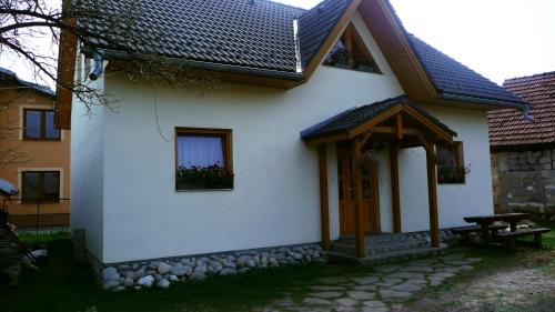 a white house with a bench and a window at Chalupa Baran in Bešeňová