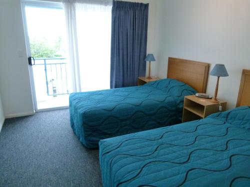 a hotel room with two beds and a window at Madison Ocean Breeze Apartments in Townsville