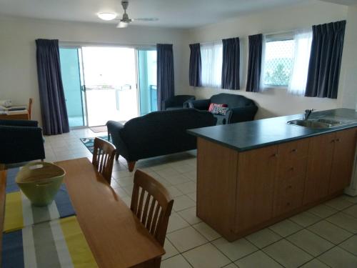 a living room with a kitchen and a living room with a table at Madison Ocean Breeze Apartments in Townsville