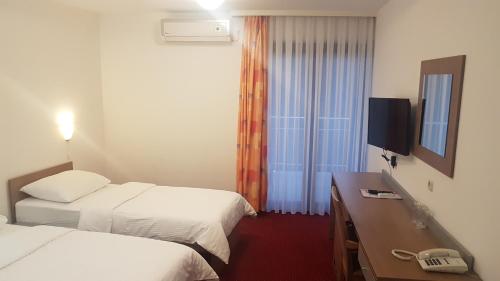 a hotel room with two beds and a television at Bed & Breakfast Zeleni Kut in Gornji Zvečaj