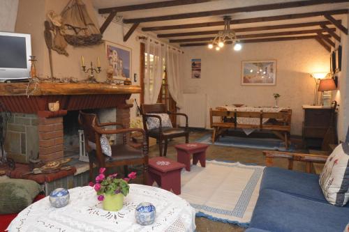 a living room with a fireplace and a table with flowers at House with Big Garden in Korinthos