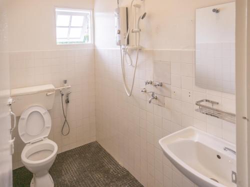 a bathroom with a shower and a toilet and a sink at Traveller Bunker Hostel 1 in Cameron Highlands