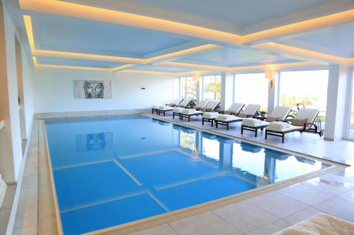 a large swimming pool with chairs in a house at Hotel Resort Märkisches Meer in Diensdorf-Radlow