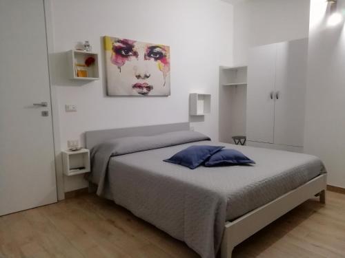 um quarto com uma cama e um quadro na parede em B&B DreAm Porto Cesareo em Porto Cesareo