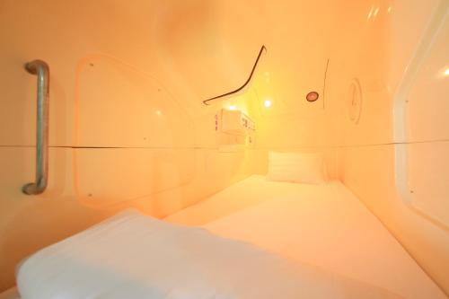 a small room with a white bed in it at Ueno Station Hostel Oriental 1 Male Only in Tokyo