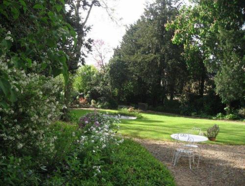 a garden with a table and chairs in the grass at Le Belvédère,double room in Bléré