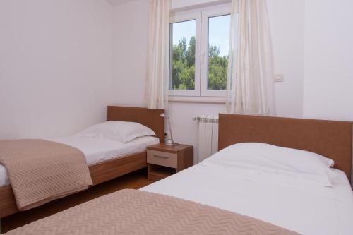 a bedroom with two beds and a window at Villa Lumare - 100m from the sea in Pula