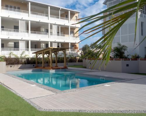 een zwembad voor een gebouw bij Tropic'Alizé, - superbe T3, piscine, à 2 min du lagon de L'Hermitage in Saint-Gilles-les-Bains