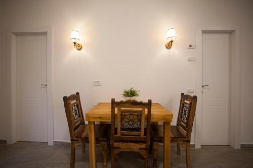 uma sala de jantar com uma mesa de madeira e cadeiras em Desert Moments em Yeroẖam