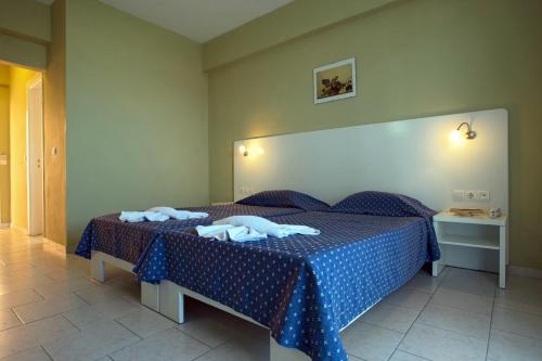 a bedroom with a blue bed with towels on it at Panorama Sidari in Sidari