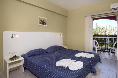 a bedroom with a bed with two towels on it at Panorama Sidari in Sidari