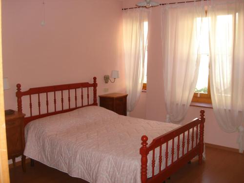 um quarto com uma cama e uma janela com cortinas em La Casetta dei Cuori em Averara