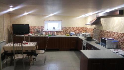 a kitchen with a table and a kitchen with a counter top at Guest house Dubrava in Velikiy Ustyug