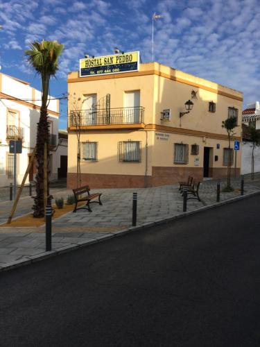 a large building with a sign on the side of it at Hostal San Pedro in Sanlúcar la Mayor
