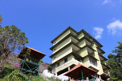 a tall yellow building with a roof at Green Valley Vista in Munnar