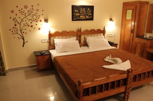 a bedroom with a large wooden bed with white pillows at Green Valley Vista in Munnar