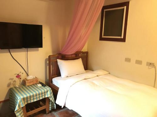 sypialnia z dwoma łóżkami i telewizorem na ścianie w obiekcie Love nostalgia No. 53 B&B w mieście Jincheng