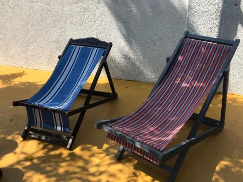 two blue chairs sitting next to a wall at Craft Hostels in Anjuna