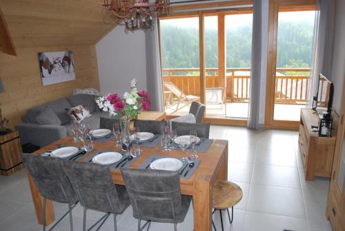 a dining room table with plates and flowers on it at LE DOMAINE DU PATRE in Vaujany