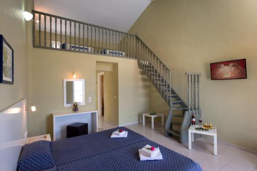 a bedroom with a blue bed and a staircase at Panorama Sidari in Sidari