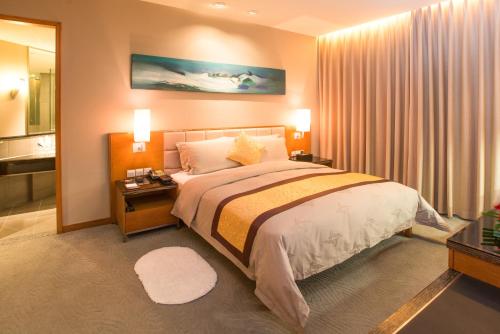 a bedroom with a large bed and a bathroom at Shenzhen Longgang Rivan Hotel in Longgang