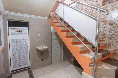 een trap in een badkamer met een wastafel bij RedDoorz Syariah At Sedati in Surabaya