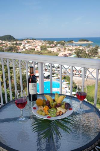 a table with a plate of food and two glasses of wine at Panorama Sidari in Sidari