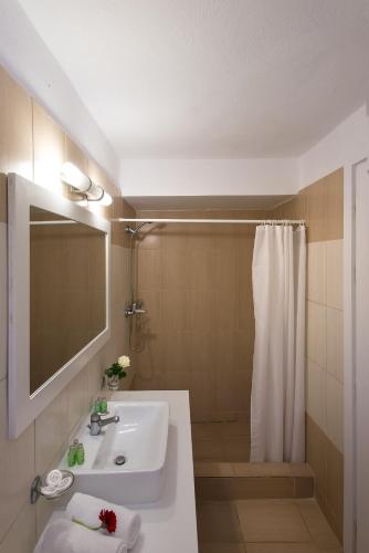 a bathroom with a sink and a shower with a mirror at Panorama Sidari in Sidari