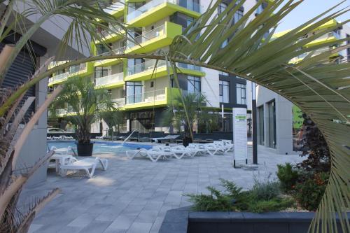 un edificio con un patio con mesas y sillas en On Beach-Mamaia Residence, en Mamaia Nord – Năvodari