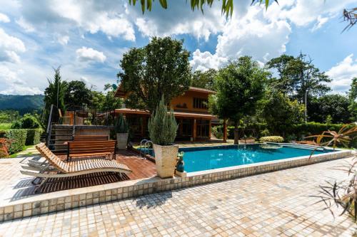 una piscina con due sedie e una casa di Phachuanchom Resort Khaoyai a Mu Si