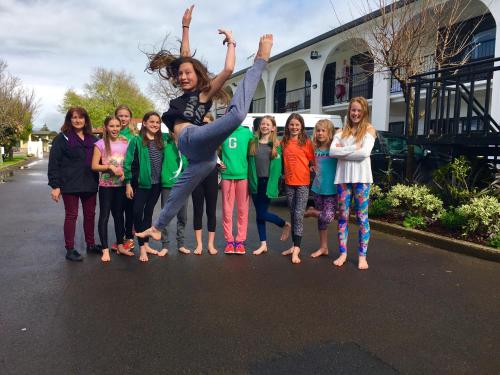 a woman jumping in the air with a group of girls at Hacienda Motor Lodge in Palmerston North