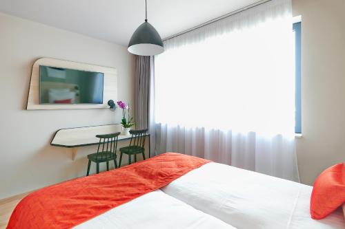 a bedroom with a bed and a table and a window at Appart'City Confort Bruxelles Centre Gare du Midi in Brussels