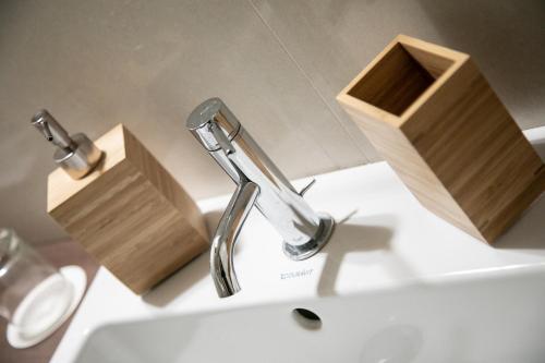 een wastafel in de badkamer met een kraan en een houten doos bij Ta Maison Bari in Bari