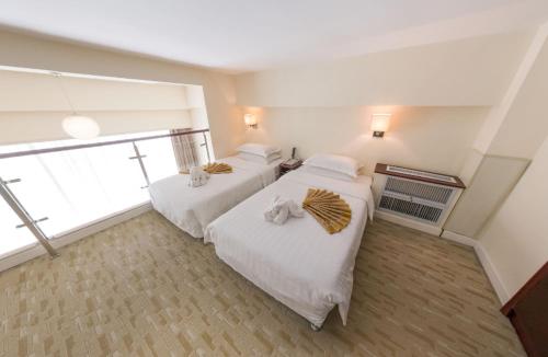 a bedroom with two beds and a large window at Fulitai International Hotel in Yantai