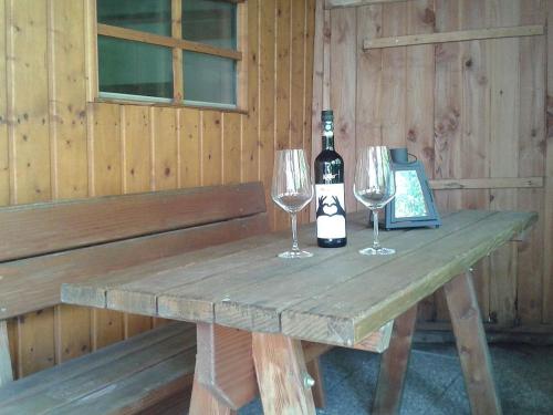 - une table en bois avec 2 verres et une bouteille de vin dans l'établissement Kasarme Auszeit, à Nördlingen