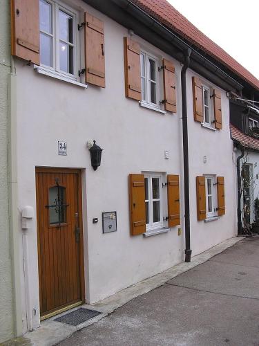 - un bâtiment blanc avec des portes et des fenêtres en bois dans l'établissement Kasarme Auszeit, à Nördlingen