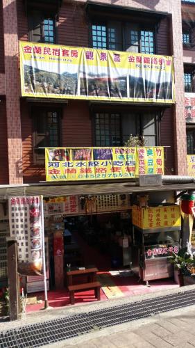 a building with signs on the side of it at 金蘭小築民宿 in Zhuqi