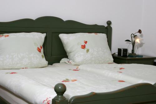 ein Bett mit weißer Bettwäsche und roten Blumen darauf in der Unterkunft Weingut Herbert Kram in Nordheim