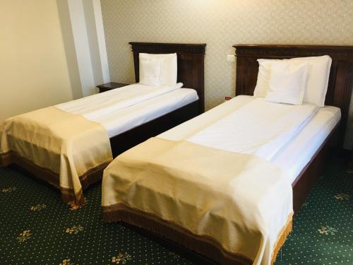 two beds sitting next to each other in a room at Popasul Caprioarei in Pădureni