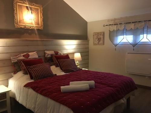 Jeuxeyにあるla Bergerieの赤い毛布が掛けられた大きなベッドのある寝室