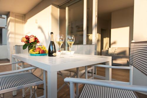 a white table with two wine glasses and a bowl of fruit at Via Firenze 11 in Follonica