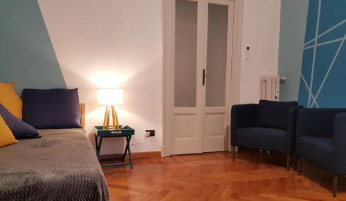 a bedroom with a bed and a chair and a lamp at SAHI - Residenza Bianca di Savoia in Milan