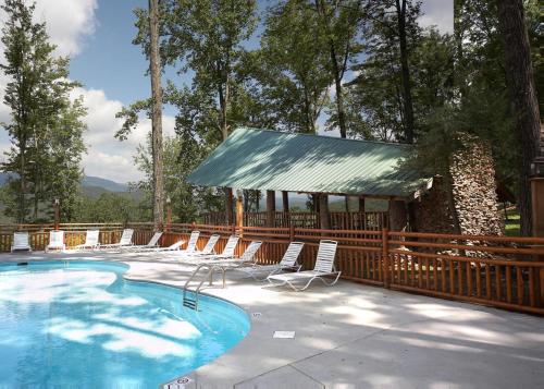 a swimming pool with chairs and a gazebo at Scenic Serenity #75 in Sevierville