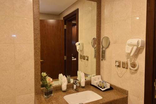 a bathroom with a sink and a mirror at Zaha Al Munawara Hotel in Al Madinah