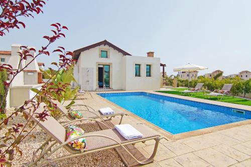 a villa with a swimming pool and a house at Villa Marion in Ayia Napa
