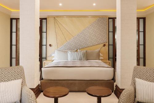 a bedroom with a bed, chair, and table at Saxon Hotel, Villas & Spa in Johannesburg