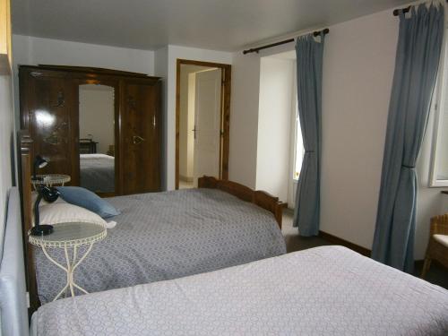 a bedroom with two beds and a mirror at Les Sources in Saint-Jacques-des-Blats