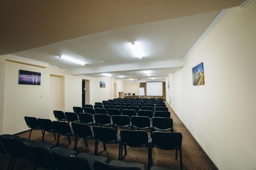 an empty room with rows of chairs in it at Globus Hotel in Ternopilʼ