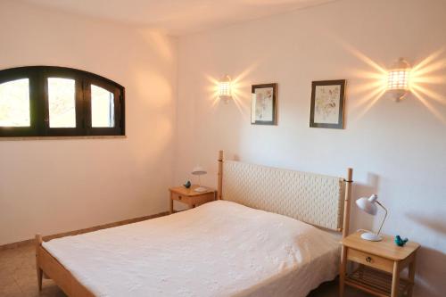 a bedroom with a bed and a window and lights at Peaceful & Spacious Apt with Parking & Queen Bed in Carvoeiro