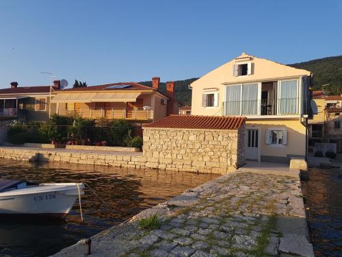 a house and a boat in a body of water at Cres view apartments in Cres